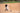 Young baseball player taking a powerful swing off a SKLZ batting tee on a dirt field, sending the ball into play.
